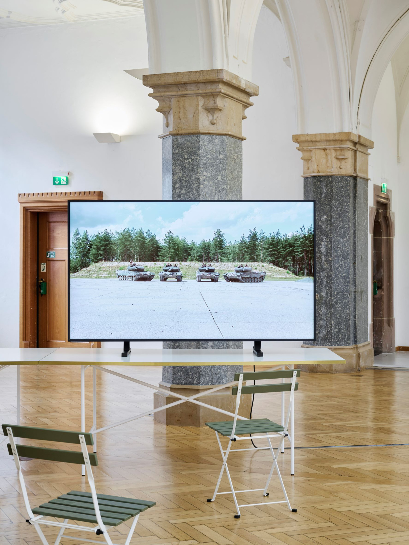 grosser-monitor-im-ausstellungsraum-zeigt-vier-panzer-arbeit-von-beate-geissler-und-oliver-sann-teil-der-ausstellung-onside-offside-rathausgalerie